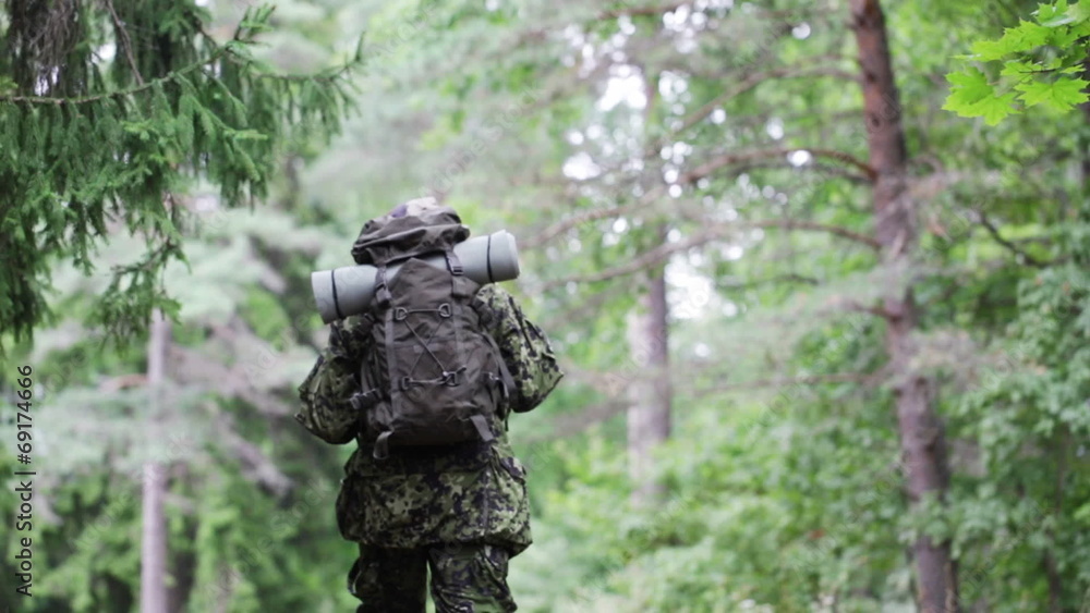 young soldier with backpack in forest young soldier with backpack in forest