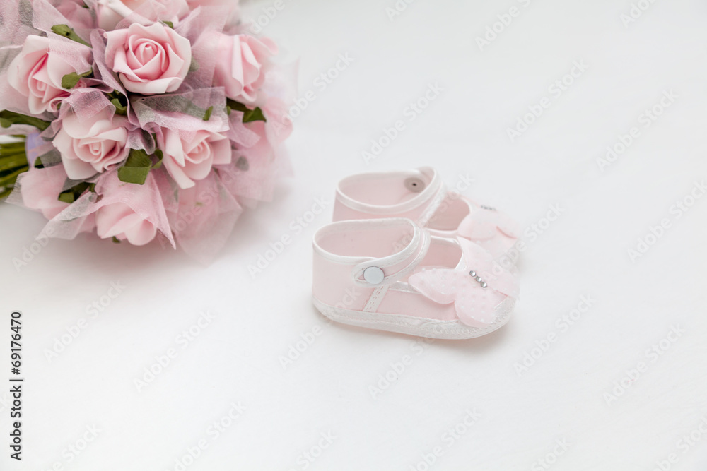 Pink flowers and children's sandals on the white bed Pink flowers and children's sandals on the white bed