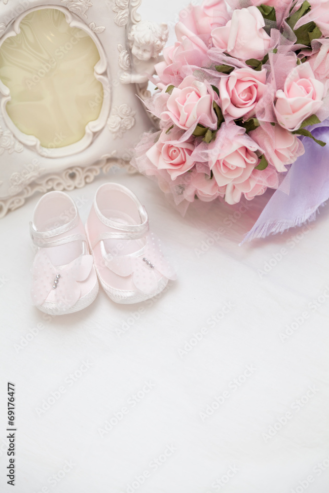 Flowers, photoframe and children's sandals on the bed Flowers, photoframe and children's sandals on the bed