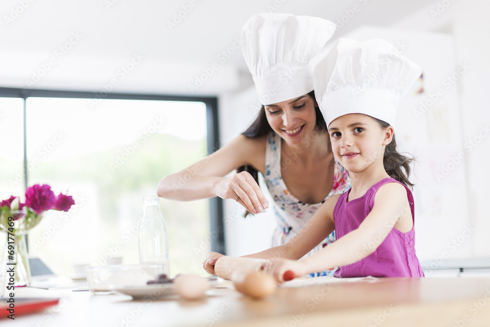 little girl helping her mother prepare a cake little girl helping her mother prepare a cake
