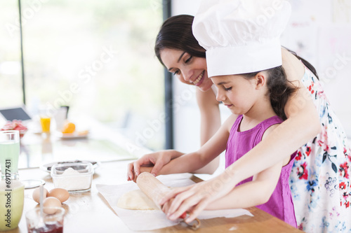 little girl helping her mother prepare a cake © jackfrog