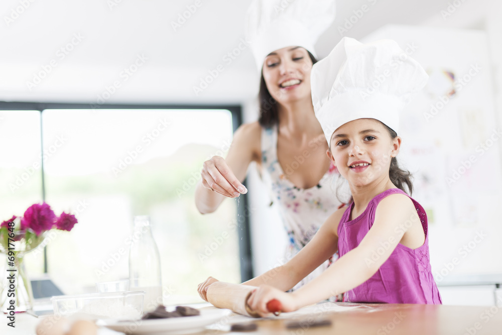 little girl helping her mother prepare a cake little girl helping her mother prepare a cake