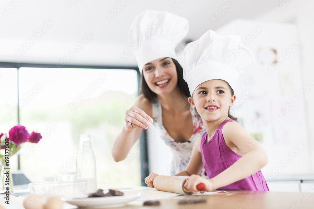 little girl helping her mother prepare a cake little girl helping her mother prepare a cake