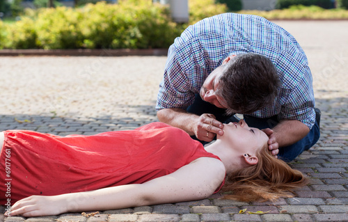 Man checking if woman's conscious