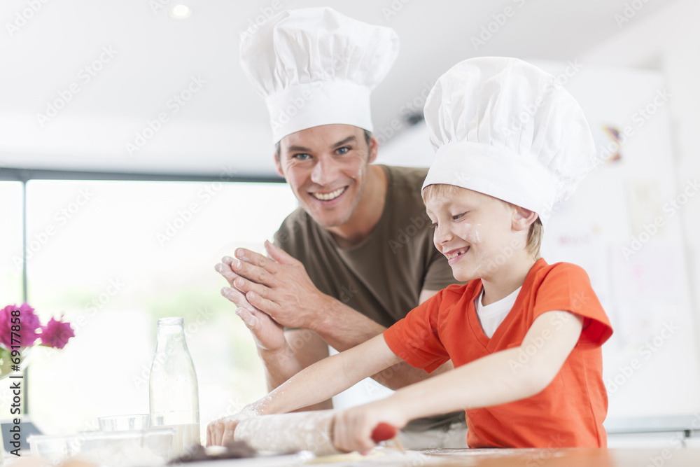 a father and his son preparing a cake in the kitchen a father and his son preparing a cake in the kitchen
