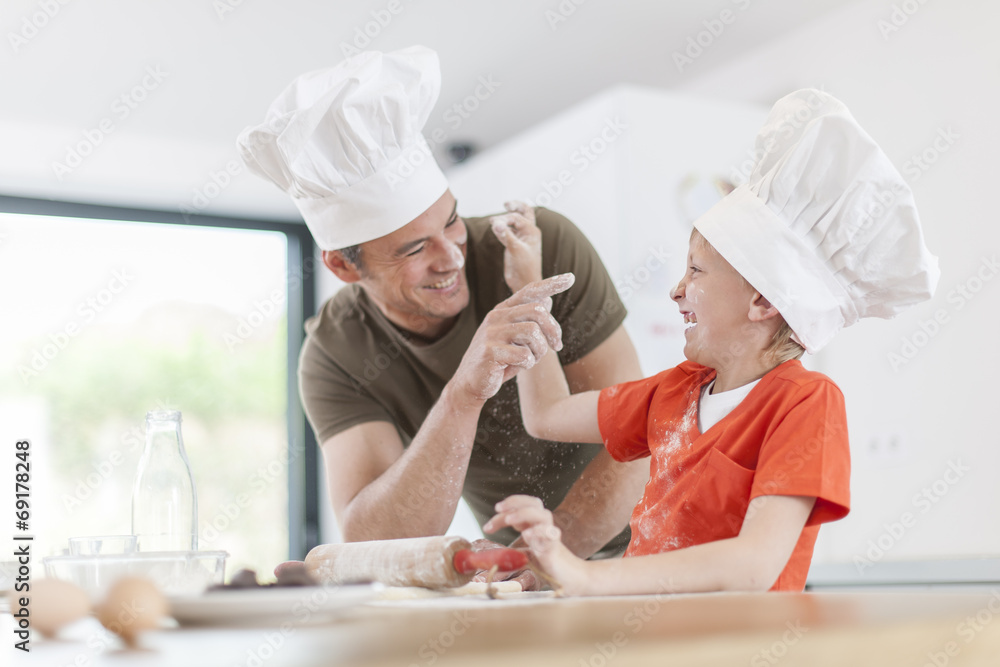 a father and his son preparing a cake in the kitchen a father and his son preparing a cake in the kitchen