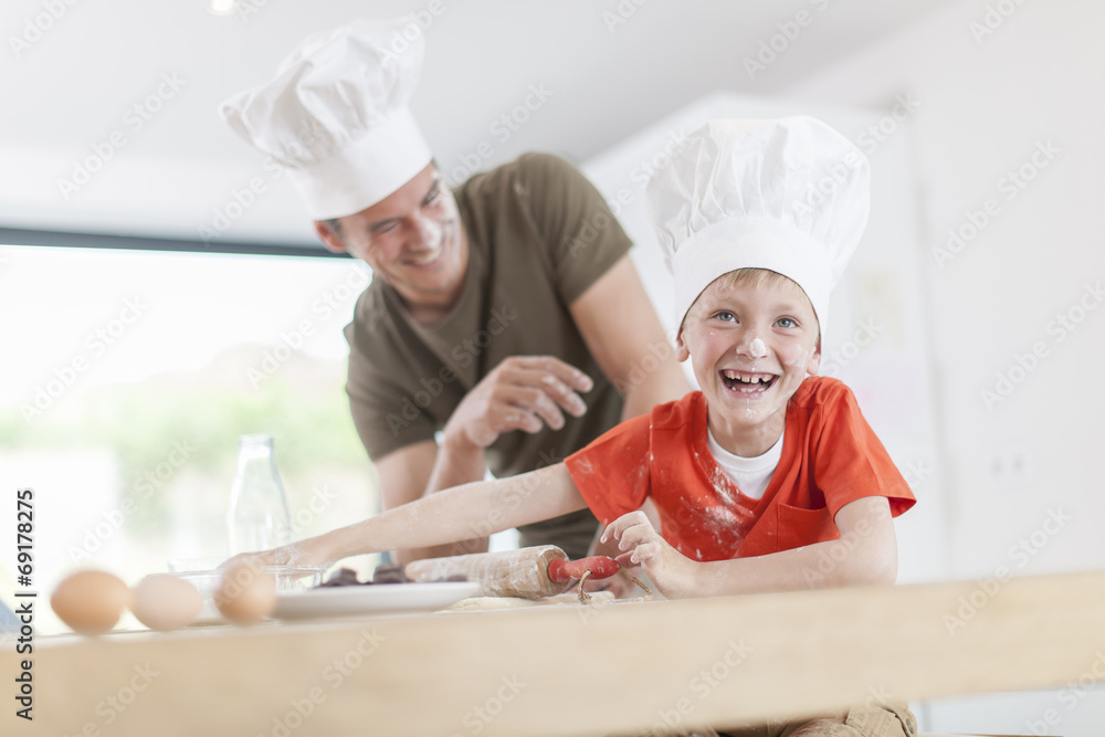 a father and his son preparing a cake in the kitchen a father and his son preparing a cake in the kitchen