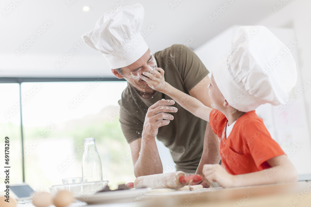 a father and his son preparing a cake in the kitchen a father and his son preparing a cake in the kitchen