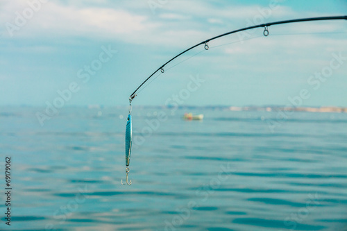 saltwater fishing - rod with wobbler and blue sea water