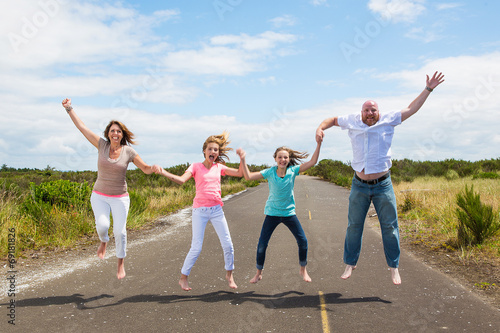 Family jumping together on the road