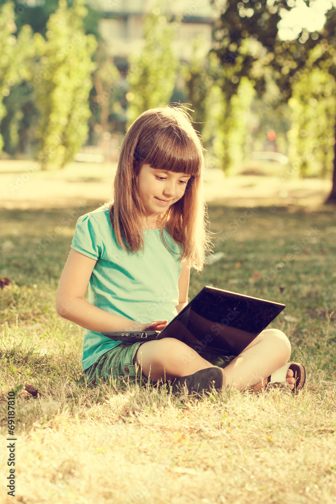 Obraz premium Little girl with laptop