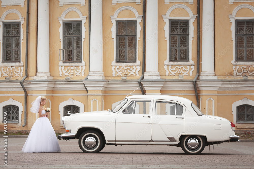 groom and bride in white vintage car
