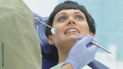 Dentist teeth carefully examines the patient girl photo