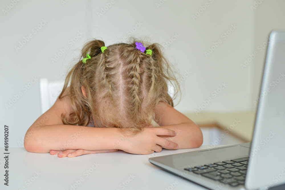 Little girl crying in front of computer at home. Stock Photo Adobe Stock