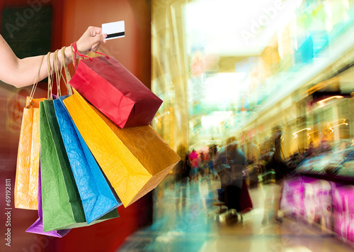 Woman holding credit card and shopping bags