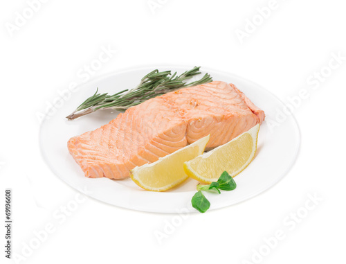 Fried salmon fillet with lemon and basil.