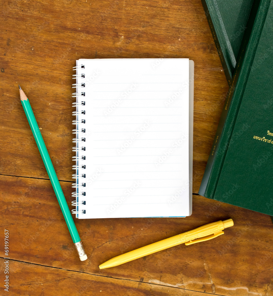 notebook and pile of books over a table notebook and pile of books over a table