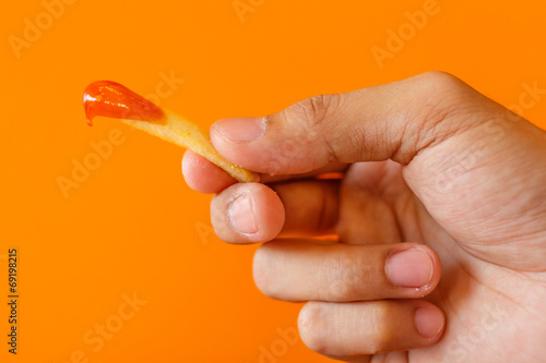 French fries and Ketchup with hand holding