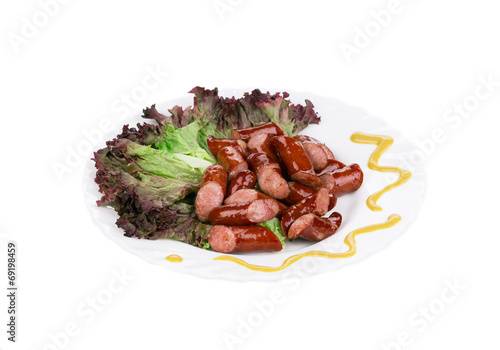 Close up of sausage salad with lettuce leaves.