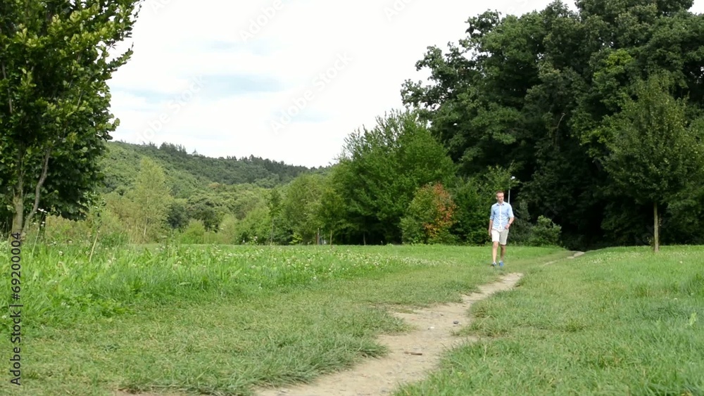 man goes alone on the pathway in the park man goes alone on the pathway in the park