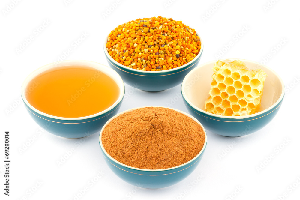 Honey, honeycomb, pollen and cinnamon in bowls Honey, honeycomb, pollen and cinnamon in bowls