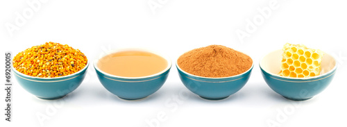 Tableau sur toile Honey, honeycomb, pollen and cinnamon in bowls