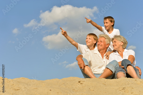 Boys with grandparents sitting on sand