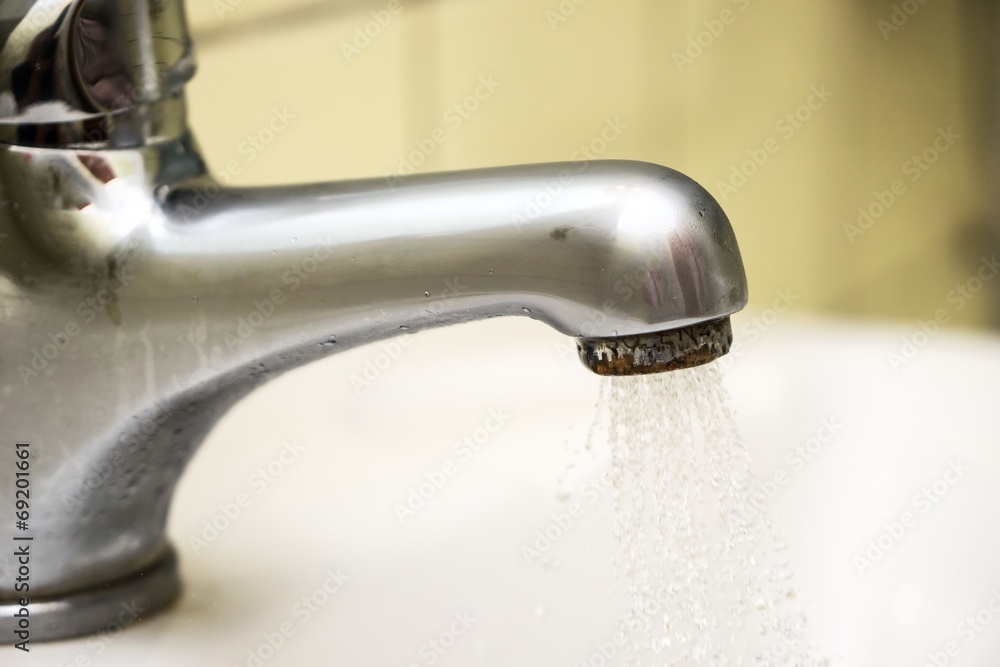 Close up of water coming out of a tap in a spray Close up of water coming out of a tap in a spray