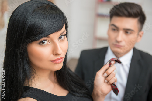 Businesswoman flirting and pulling her colleague by the tie, rel