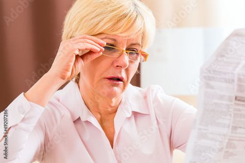 Seniorin liest mit Altersweitsichtigkeit Beipackzettel 