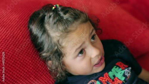 Boy lying on red sofa and singing a song photo