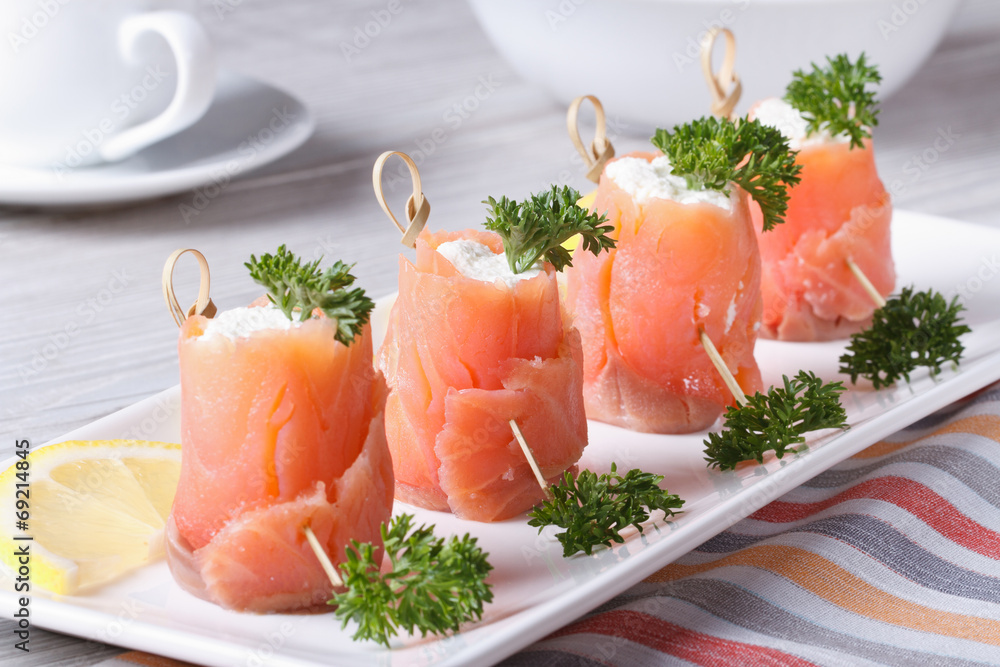 Rolls of salmon with cream cheese close-up horizontal