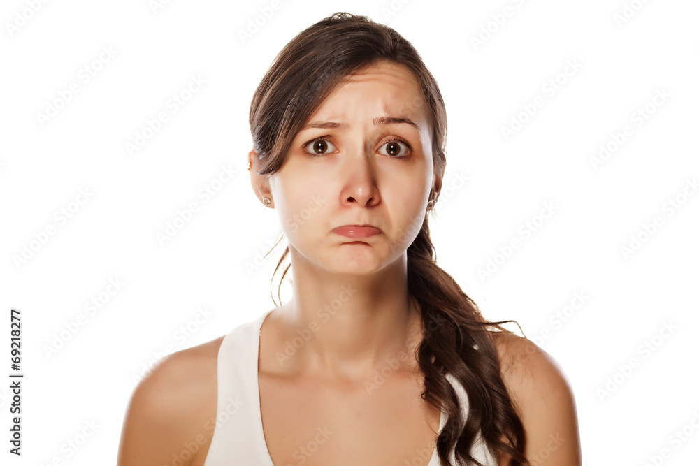 confused young woman posing on a white background