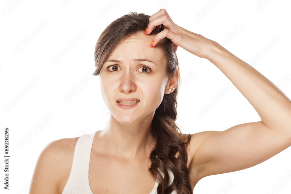 Funny young woman has itching on her head