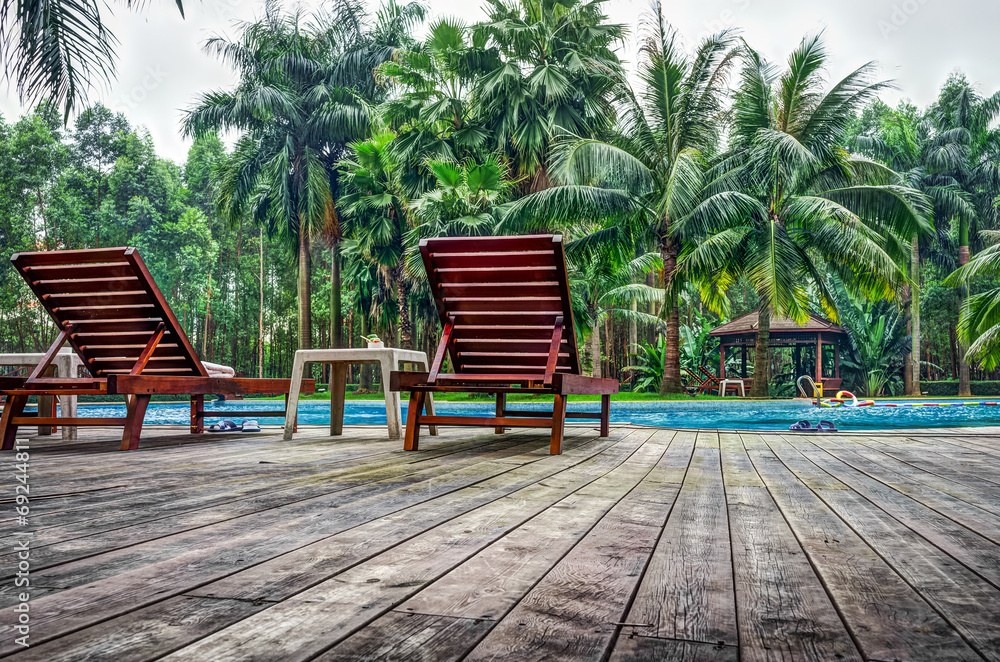 Wooden sunbath chair and side table in swimming pool Wooden sunbath chair and side table in swimming pool