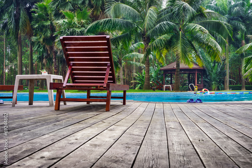 Wooden sunbath chair and side table in swimming pool © joeyphoto