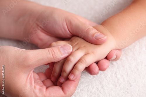 Mother massaging child's hand