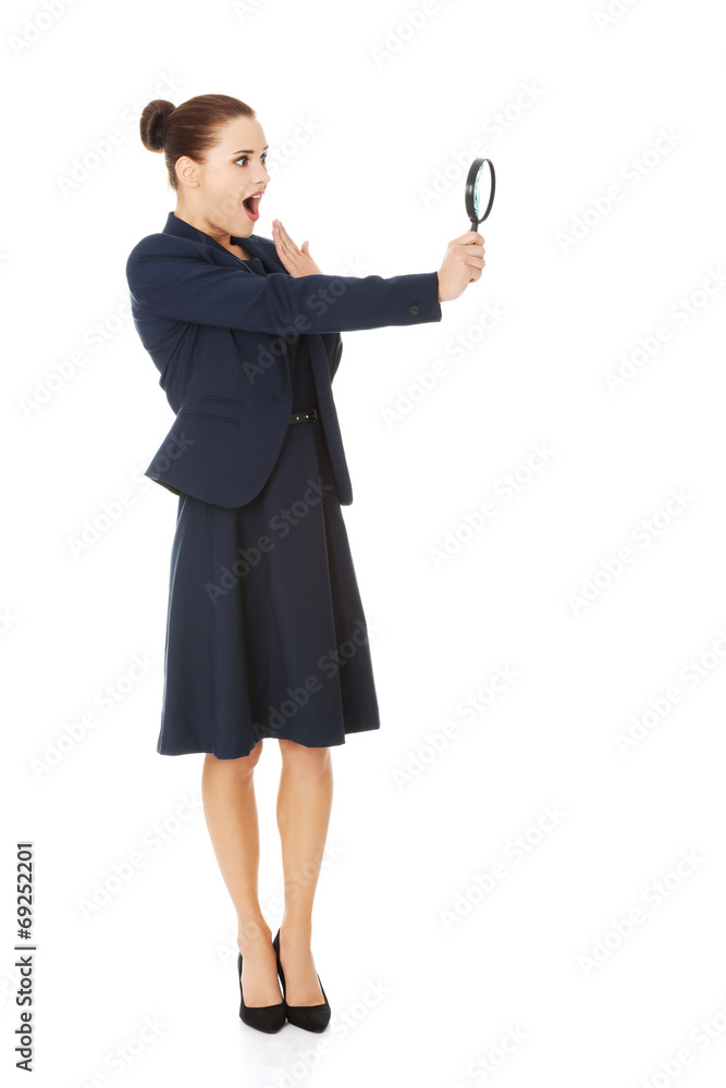 Business woman looking into a magnifying glass