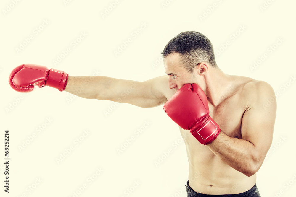 Muscular man wearing red boxing gloves and punching