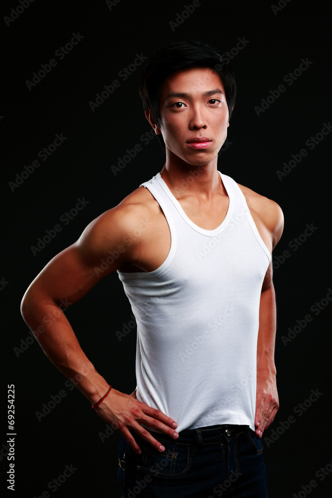 Portrait of a serious muscular asian man on black background Portrait of a serious muscular asian man on black background