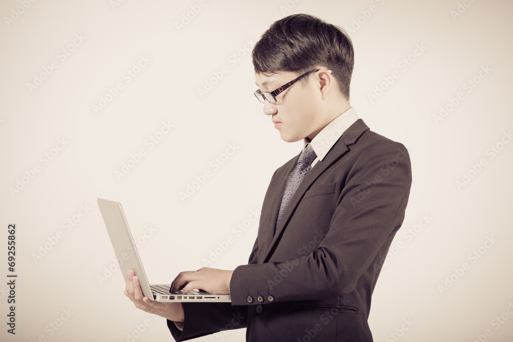 Asian business man using laptop computer isolated on white backg Asian business man using laptop computer isolated on white backg