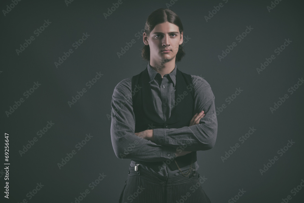 Western 1900 fashion man with brown hair. Studio shot against gr Western 1900 fashion man with brown hair. Studio shot against gr