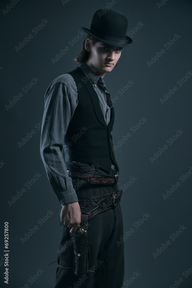 Western 1900 fashion man with brown hair and hat holding gun. St Western 1900 fashion man with brown hair and hat holding gun. St