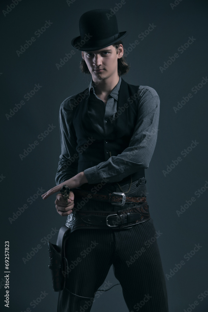 Western 1900 fashion man with brown hair and hat shooting with g Western 1900 fashion man with brown hair and hat shooting with g