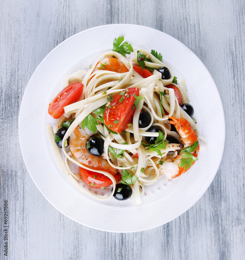 Fresh prawns with spaghetti, olives, tomatoes and parsley in a Fresh prawns with spaghetti, olives, tomatoes and parsley in a