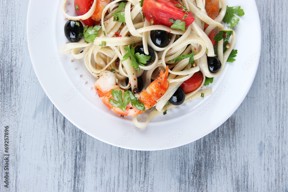 Fresh prawns with spaghetti, olives, tomatoes and parsley in a Fresh prawns with spaghetti, olives, tomatoes and parsley in a