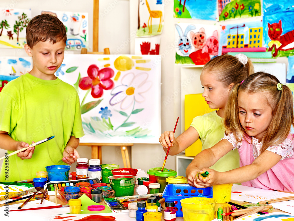 Naklejka premium Child painting at easel.