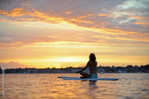 Frau auf Surfboard bei Sonnenaufgang © bevisphoto