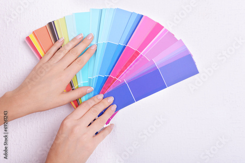 Woman choosing color for wall from swatches in room © Africa Studio