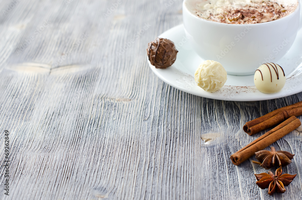 Pralines and a cup of cappuccino copy space wooden background Pralines and a cup of cappuccino copy space wooden background